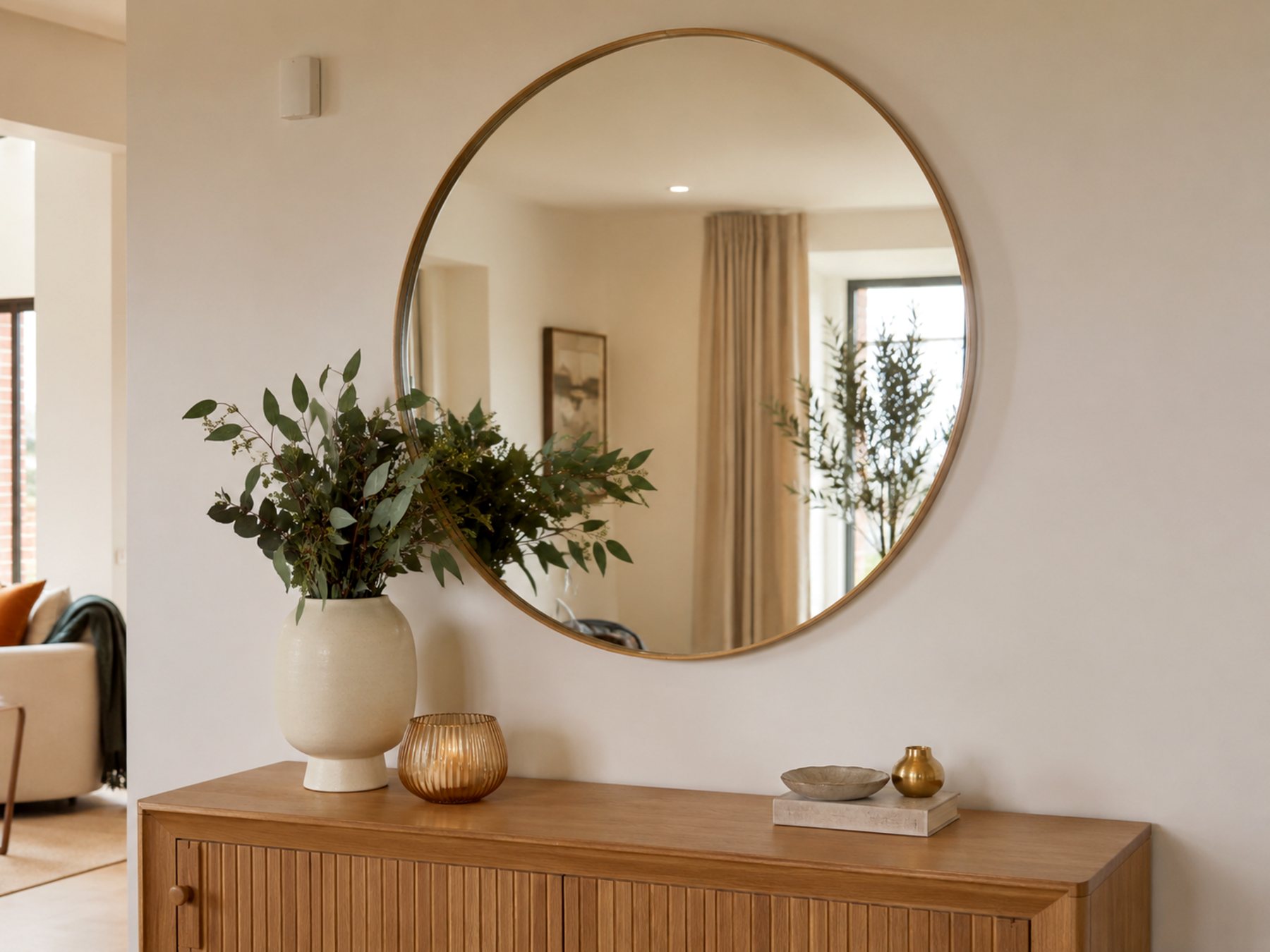 Large round mirror hung neatly above timber console