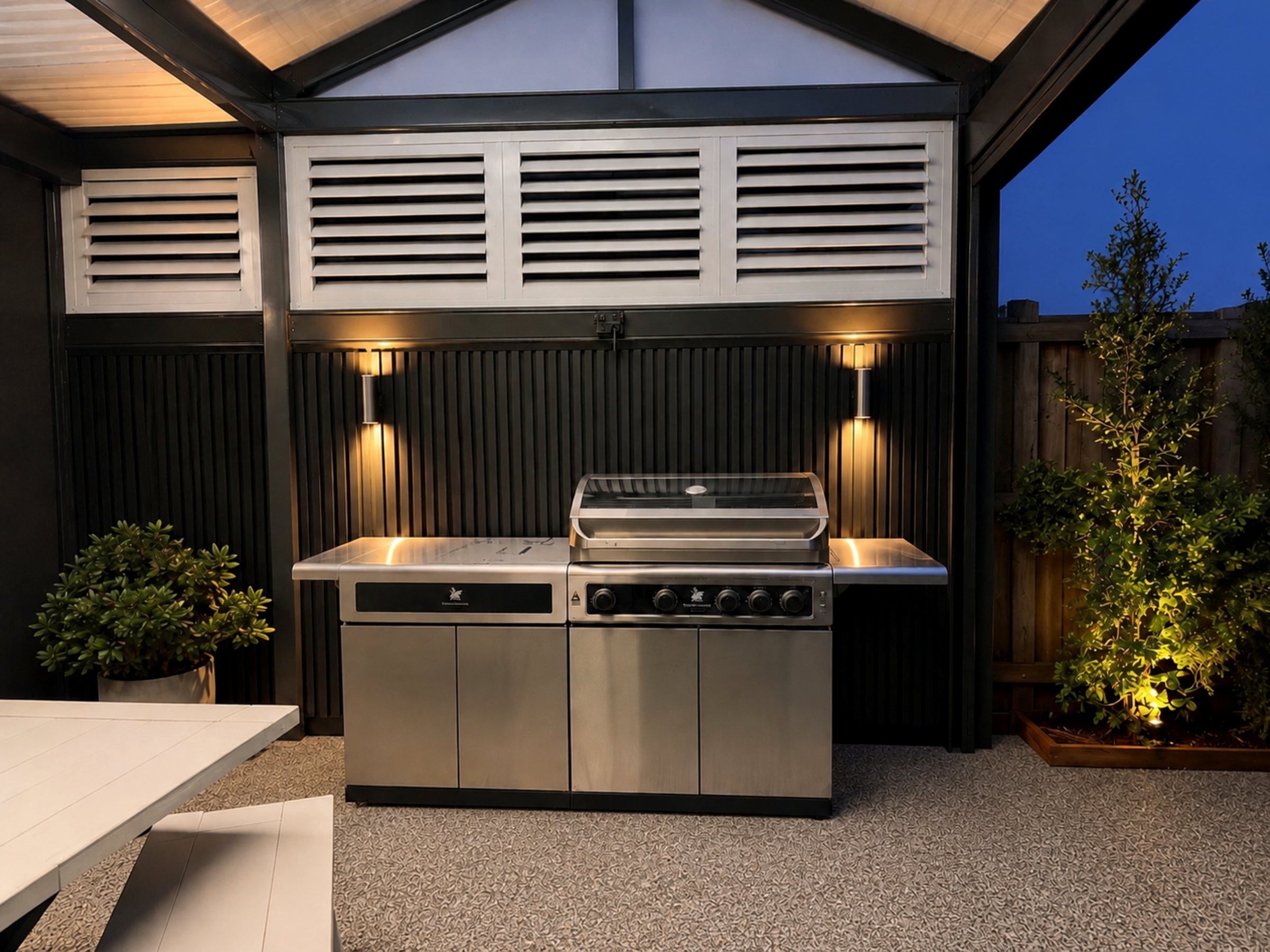 Covered outdoor entertaining area with barbeque and warm feature lighting