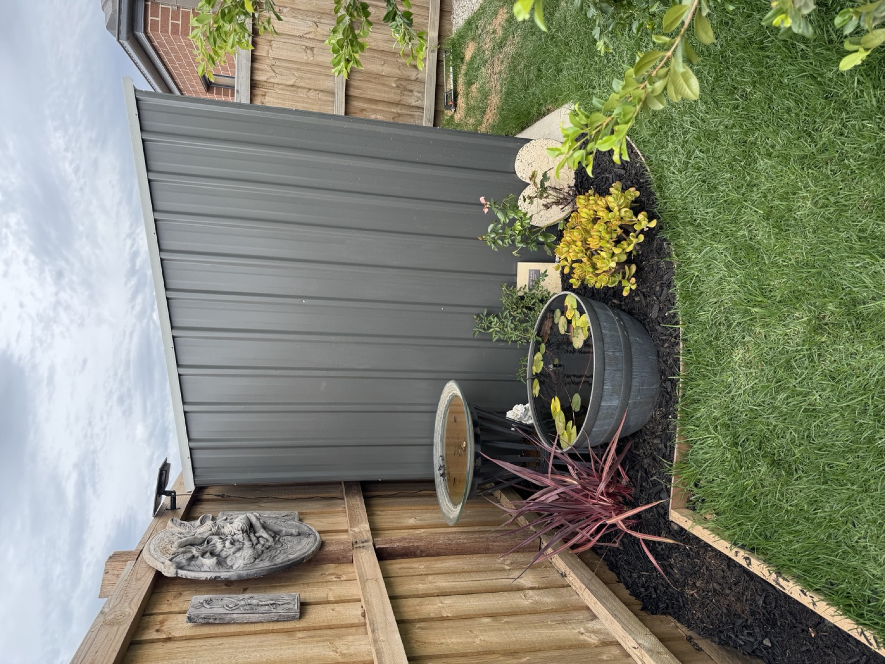 Finished garden corner with lawn, mulch, timber fence and planted feature area